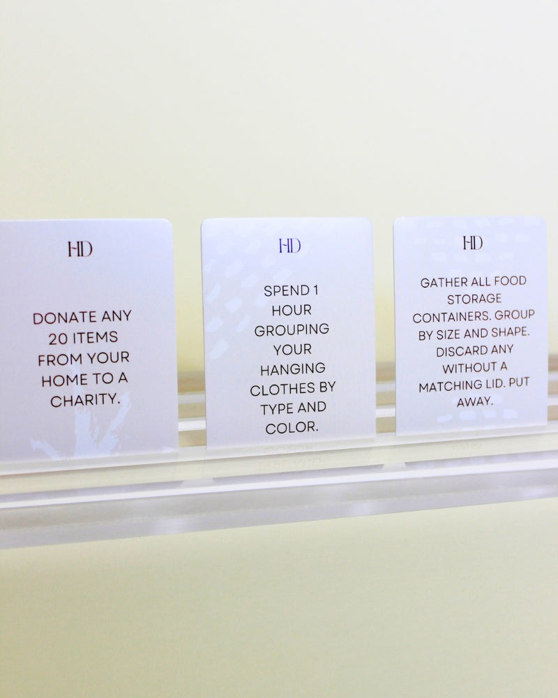 Three white Declutter Deck cards for decluttering and organizing with black text on a white surface