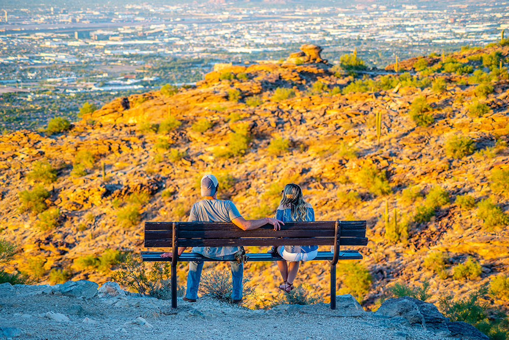 Couple sitting on bench overlooking scenic view