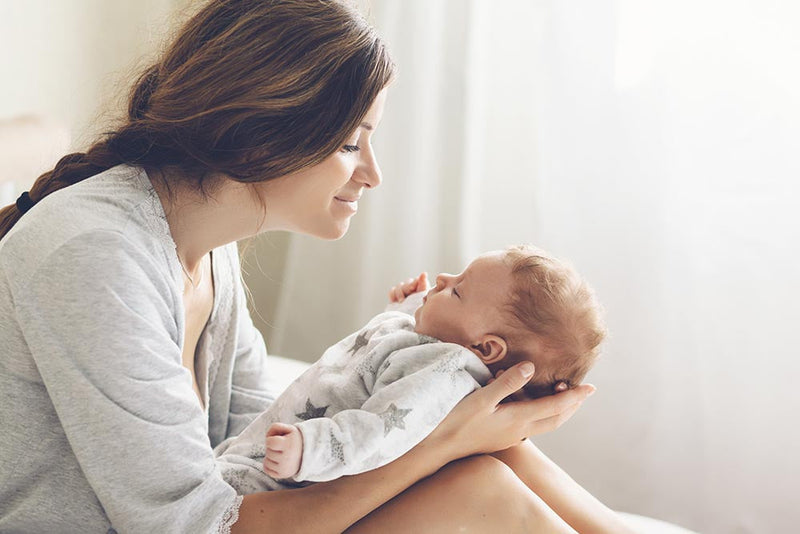 Mother holding newborn baby peacefully life hacks for new moms