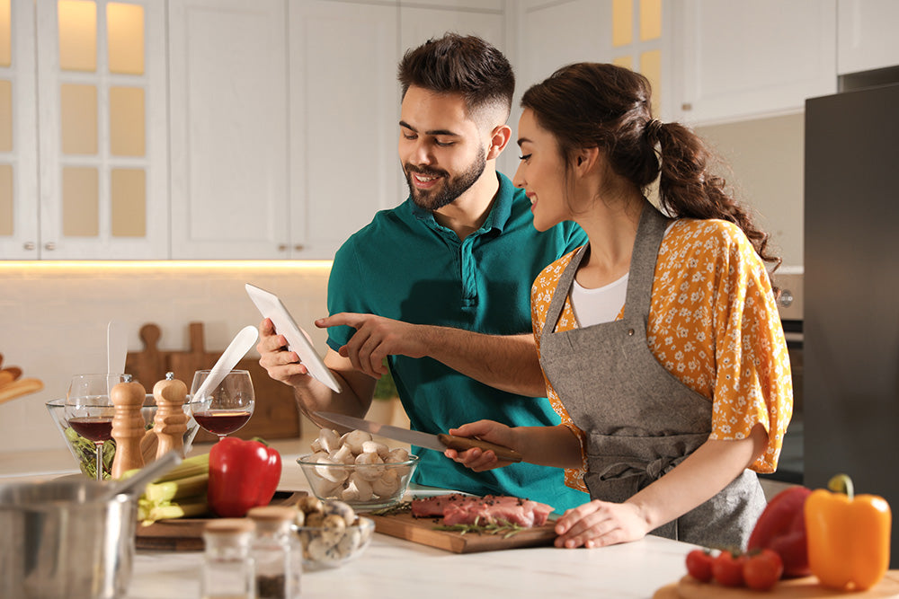 Couple cooking together in a well-lit kitchen