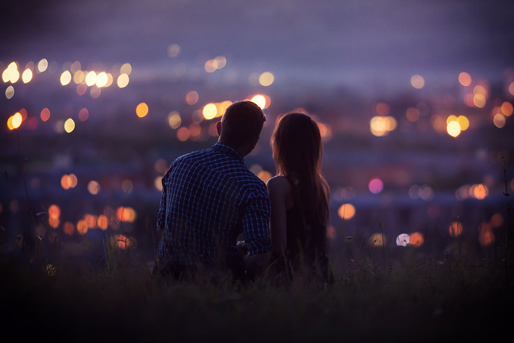 Couple sitting on a hill during sunset