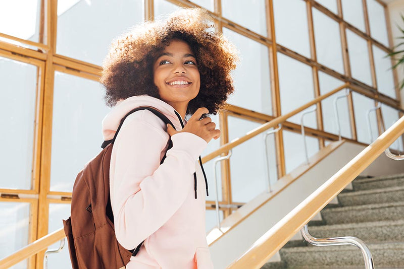 Smiling student standing near window college freshman success