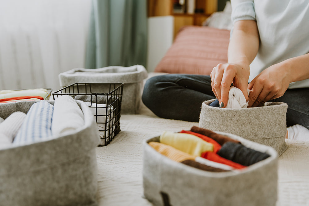 Organizing clothes into storage bins ADHD and decluttering