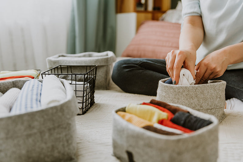 Organizing clothes into storage bins ADHD and decluttering