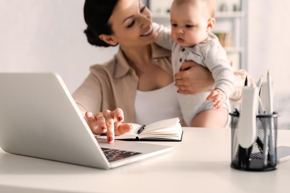Mother working at desk with baby