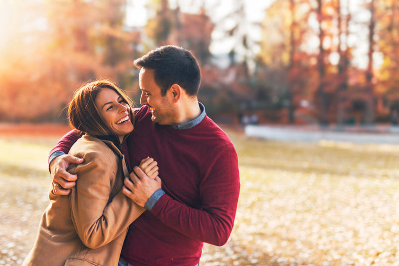Couple smiling and hugging outdoors science of attraction