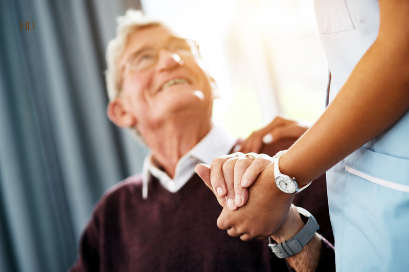 Person helping elderly with a handshake