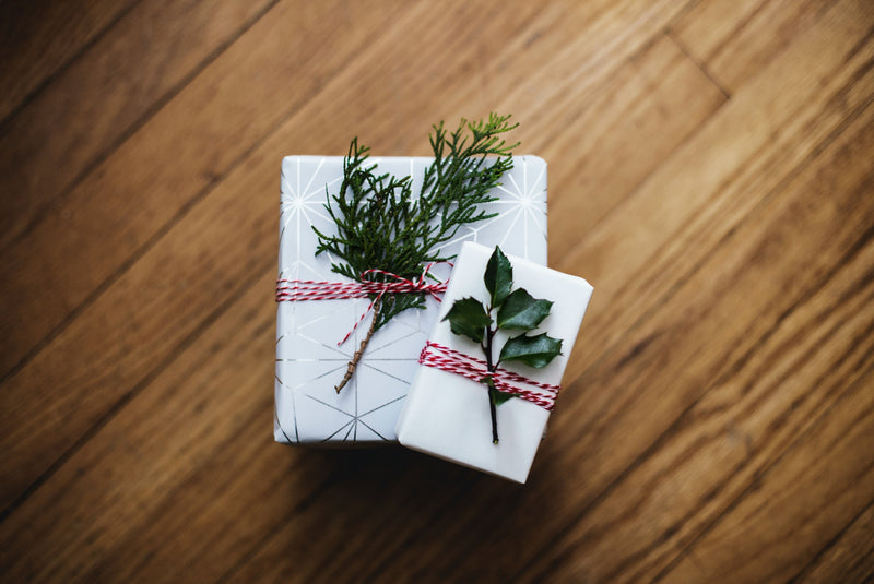 White gifts with pine branch decor Keyword "holiday gifts for new moms