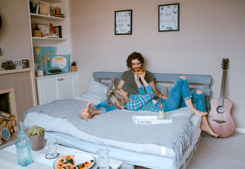 Parents lounging on bed with baby