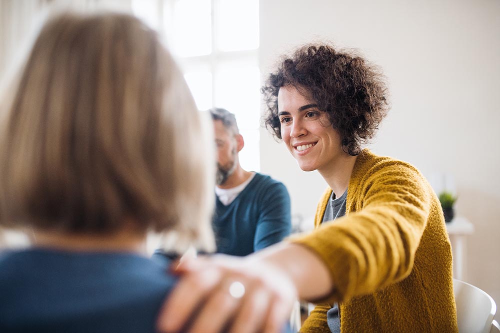 acts of kindness and mental health Woman comforting child in classroom setting
