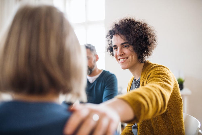 acts of kindness and mental health Woman comforting child in classroom setting