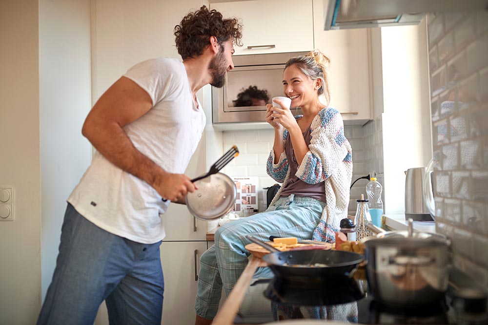 Smiling couple cooking together in kitchen