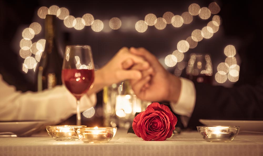 Couple holding hands at dinner