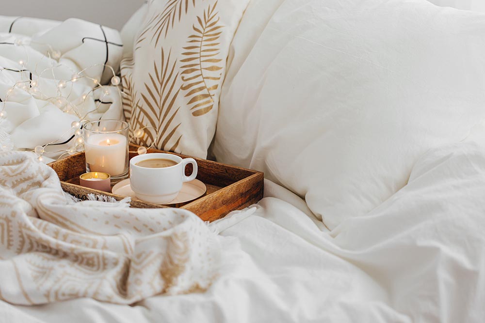 Cozy bed with tea and book