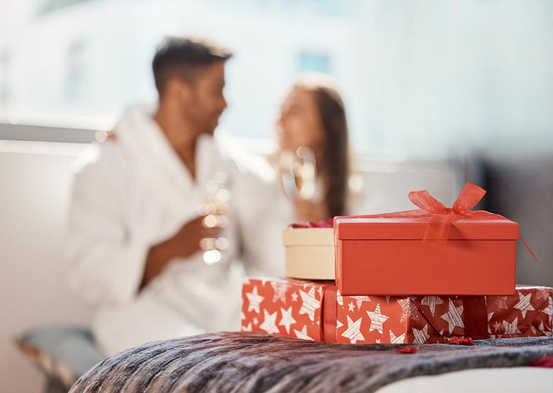 Couple smiling with gift boxes date night ideas for couples