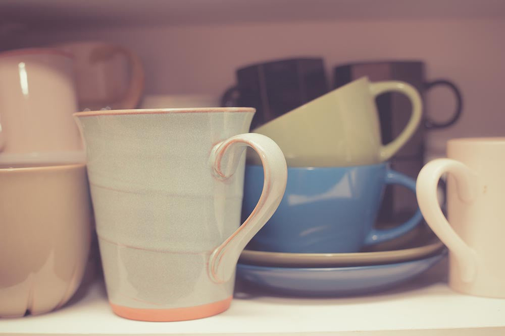 Pastel mugs on kitchen table how to declutter mugs