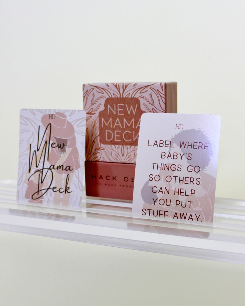 Three 'New Mama Deck' products on a white surface with a light background